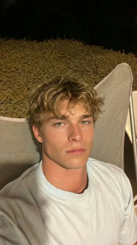 Relaxed blonde AI boyfriend in a white T-shirt outdoors